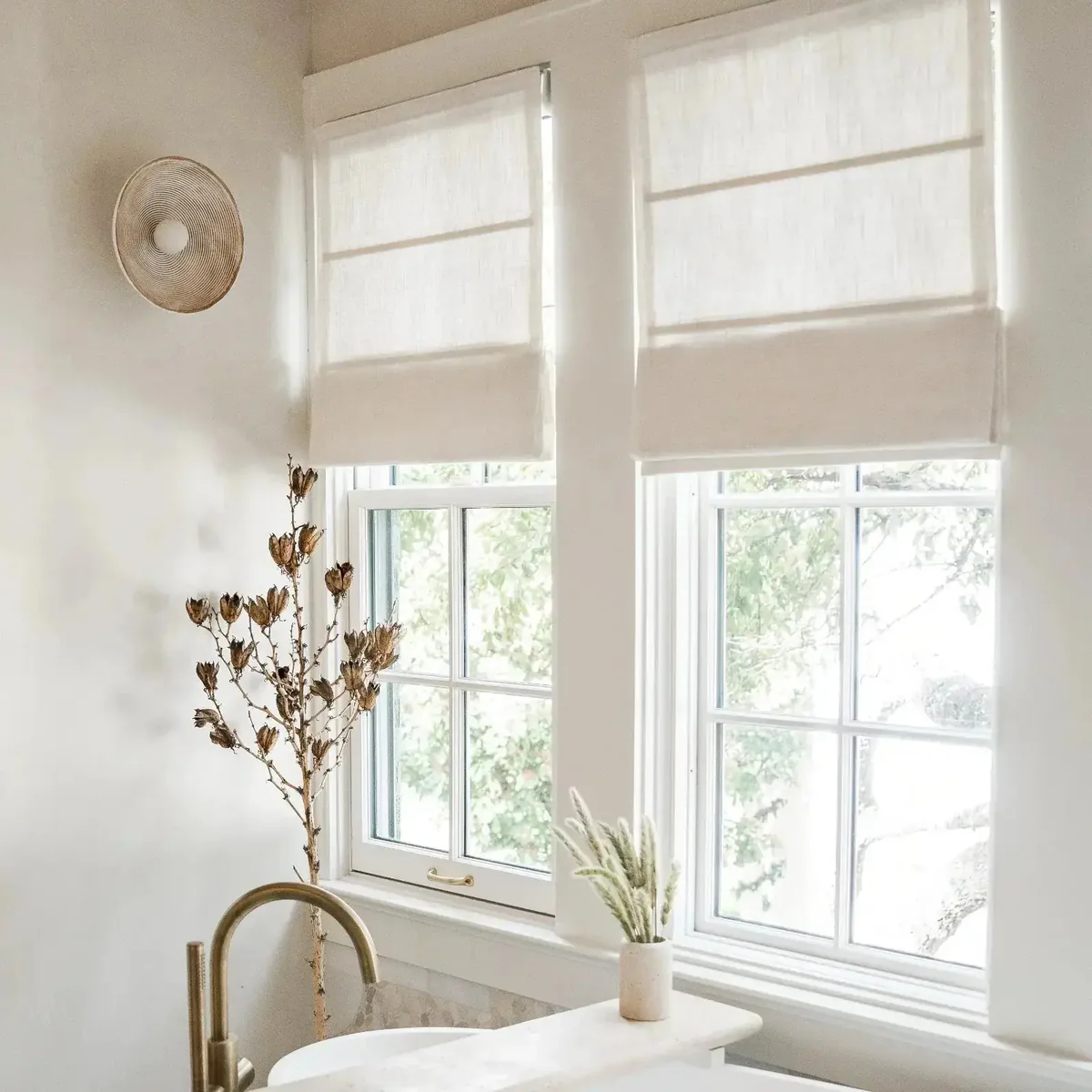 Beige white TWOPAGES Liz cordless Roman shade mounted inside a window frame